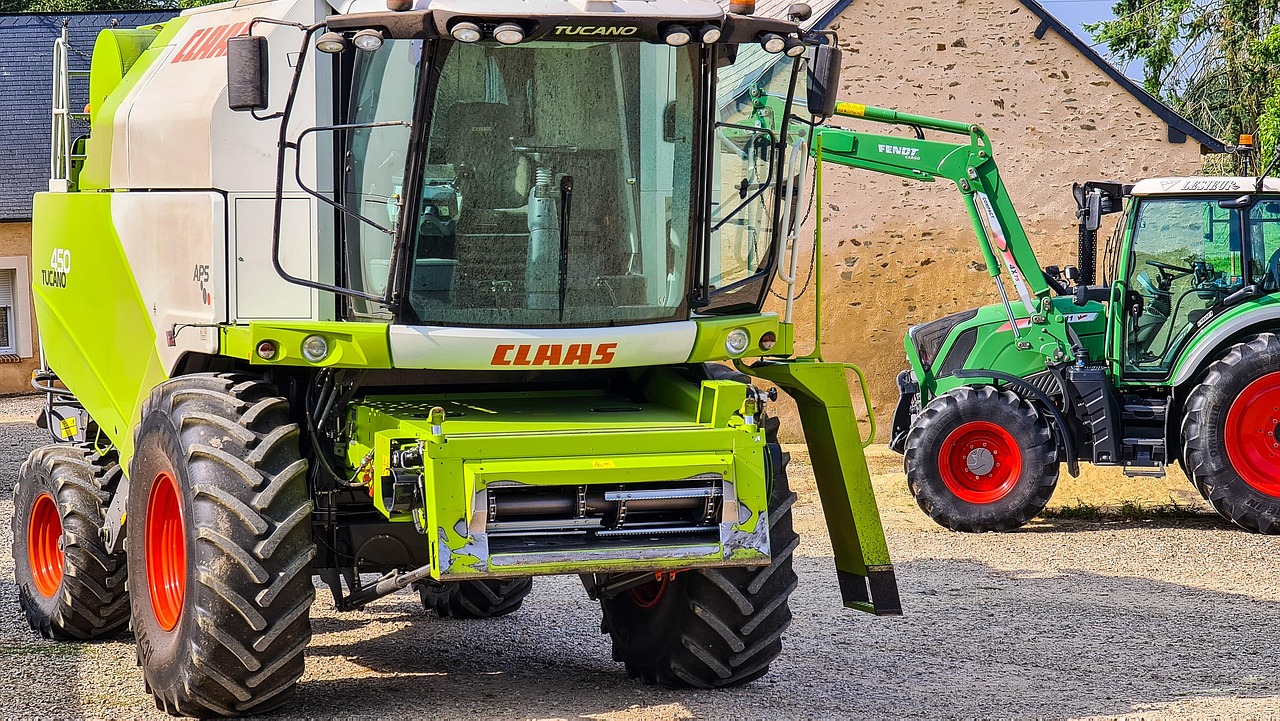 Moissonneuse-batteuse Claas Tucano et tracteur Fendt stationnés dans une cour de ferme